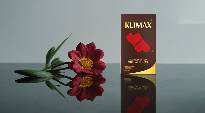 Klimax condom pack beside a red flower, highlighting technology for Mutual Climax.