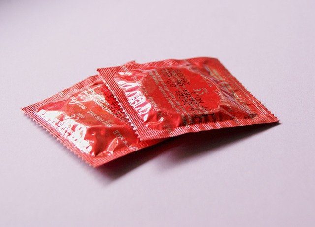 Two red condom packets placed together, representing safe intimacy with Mutual Climax protection.