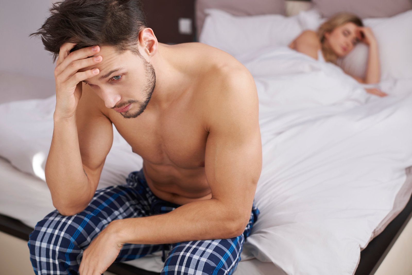 Man looking stressed in bed after failed Safe mutual climax attempt